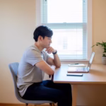 Job seeker carefully reviewing a remote job offer email on a laptop at home